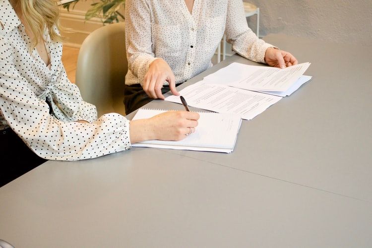 women taking notes and discussing documents